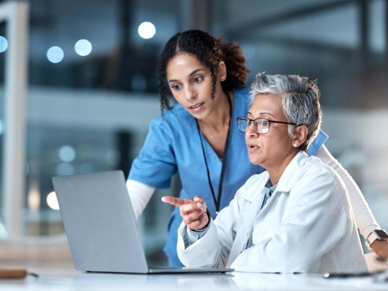 Two women looking up questions about malpractice insurance for nurses