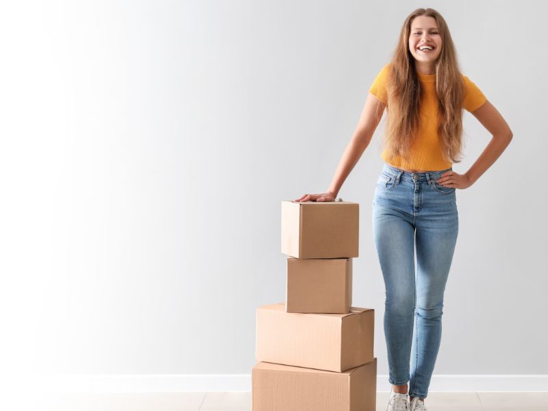 woman standing next to stack of boxes