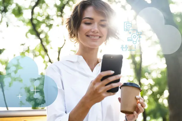 Woman smiling looking at mobile phone holding coffee