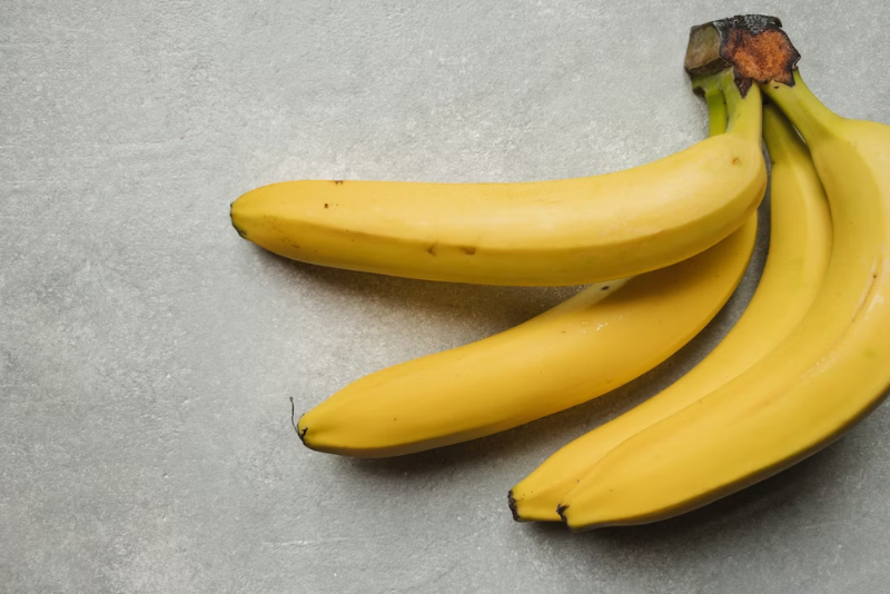 Four bananas laying on table