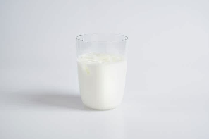 A glass of milk sitting on a white table