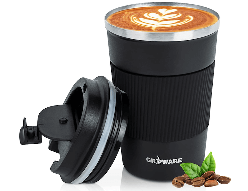 A black coffee mug tumbler with its lid leaning up against it holding a latte