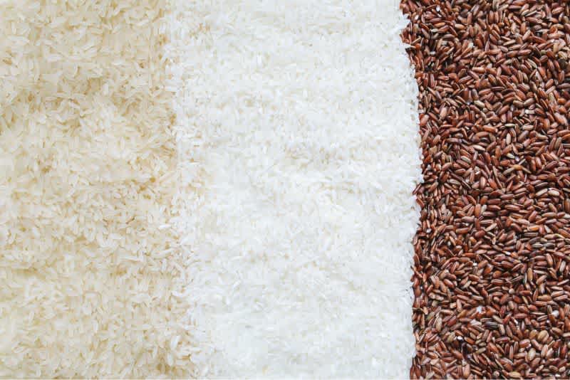 Uncooked brown, white, and wild rice next to each other.