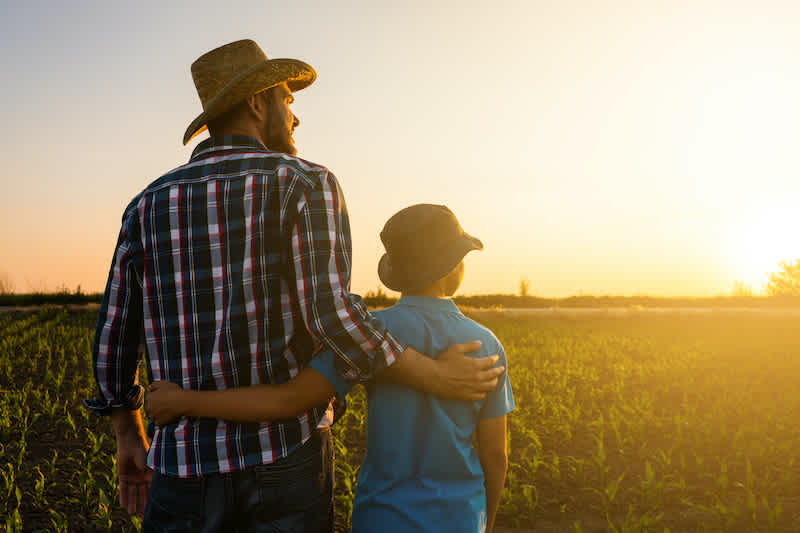 Rancher and son in field