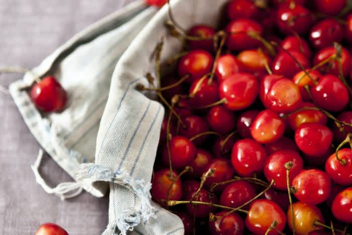 a bowl of red cherries on a table