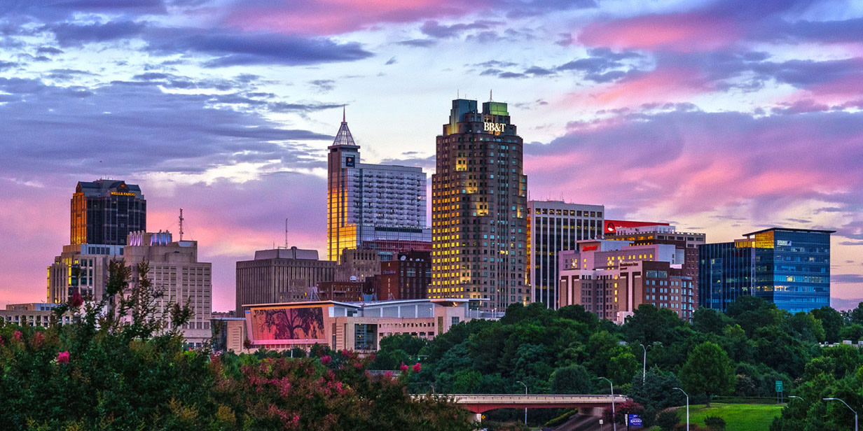This is a beautiful picture of the Raleigh sky line with a beautiful cotton candy sky 