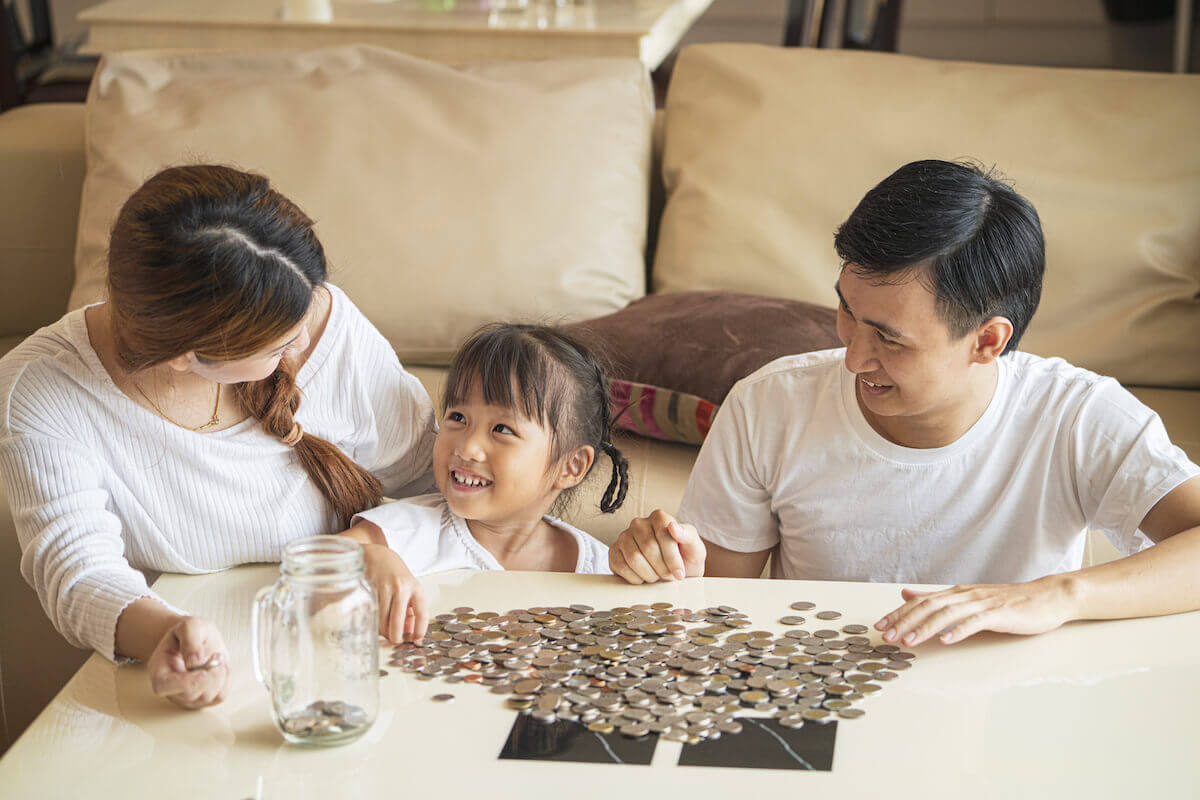 Family sorting through coins and putting it in a jar