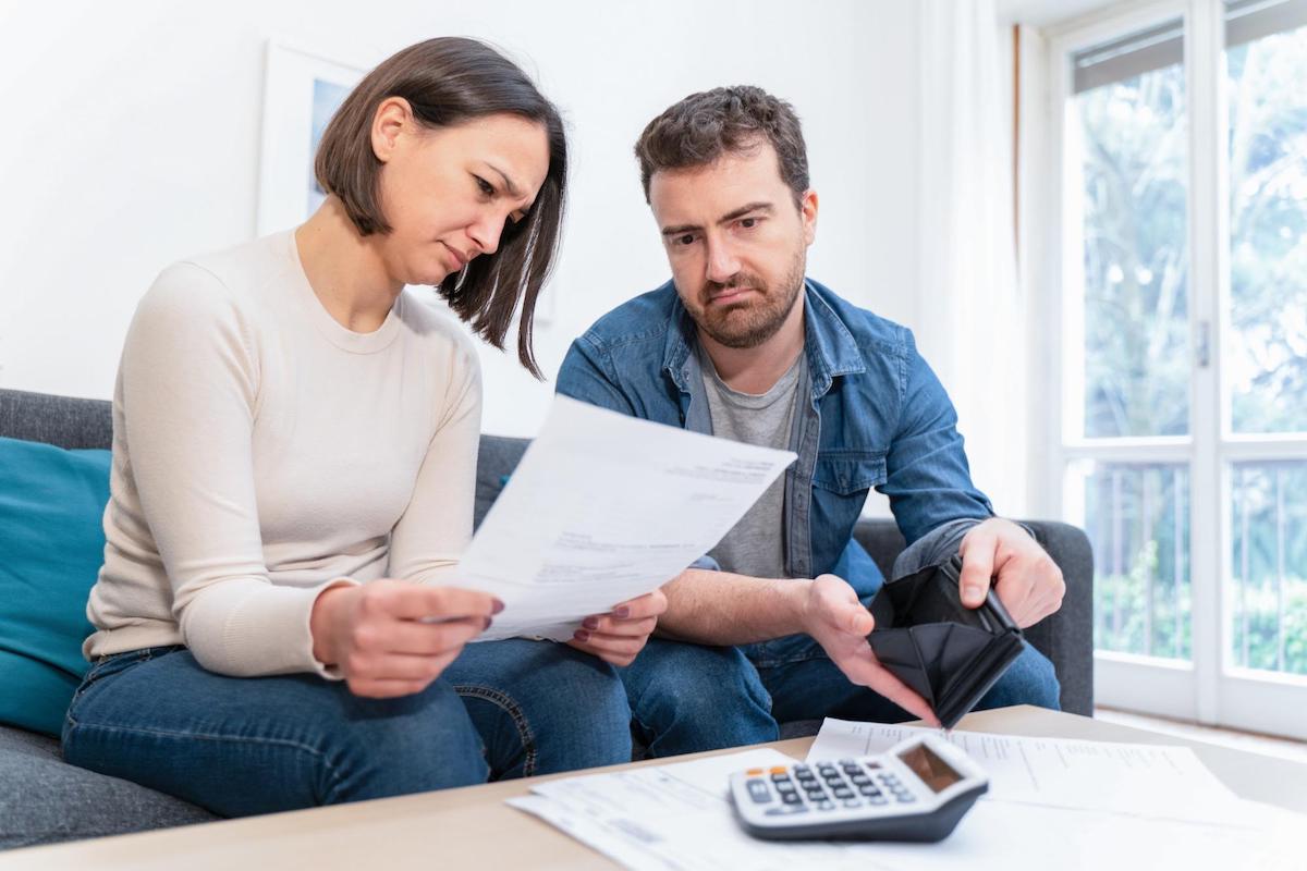 Do you have to pay back unemployment: worried couple looking at their bills