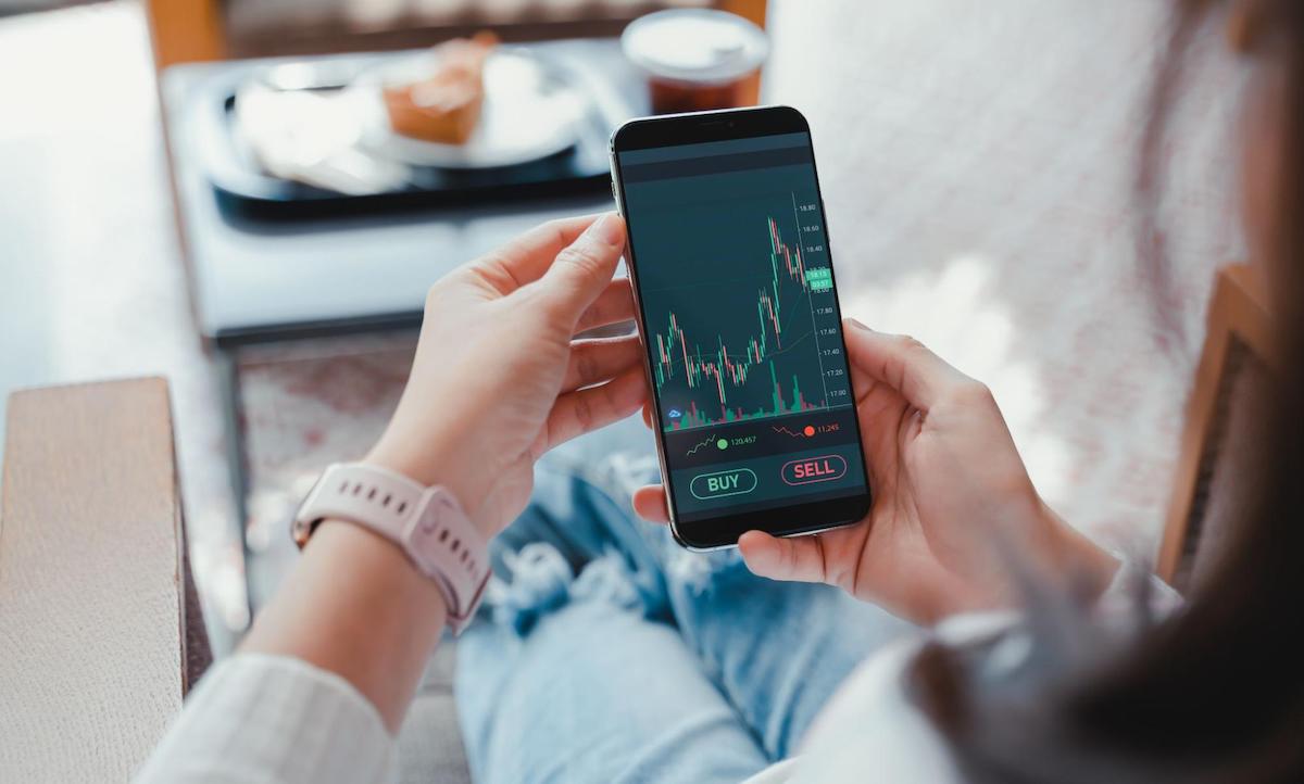 How to become wealthy: Woman looks at stock charts on iPhone