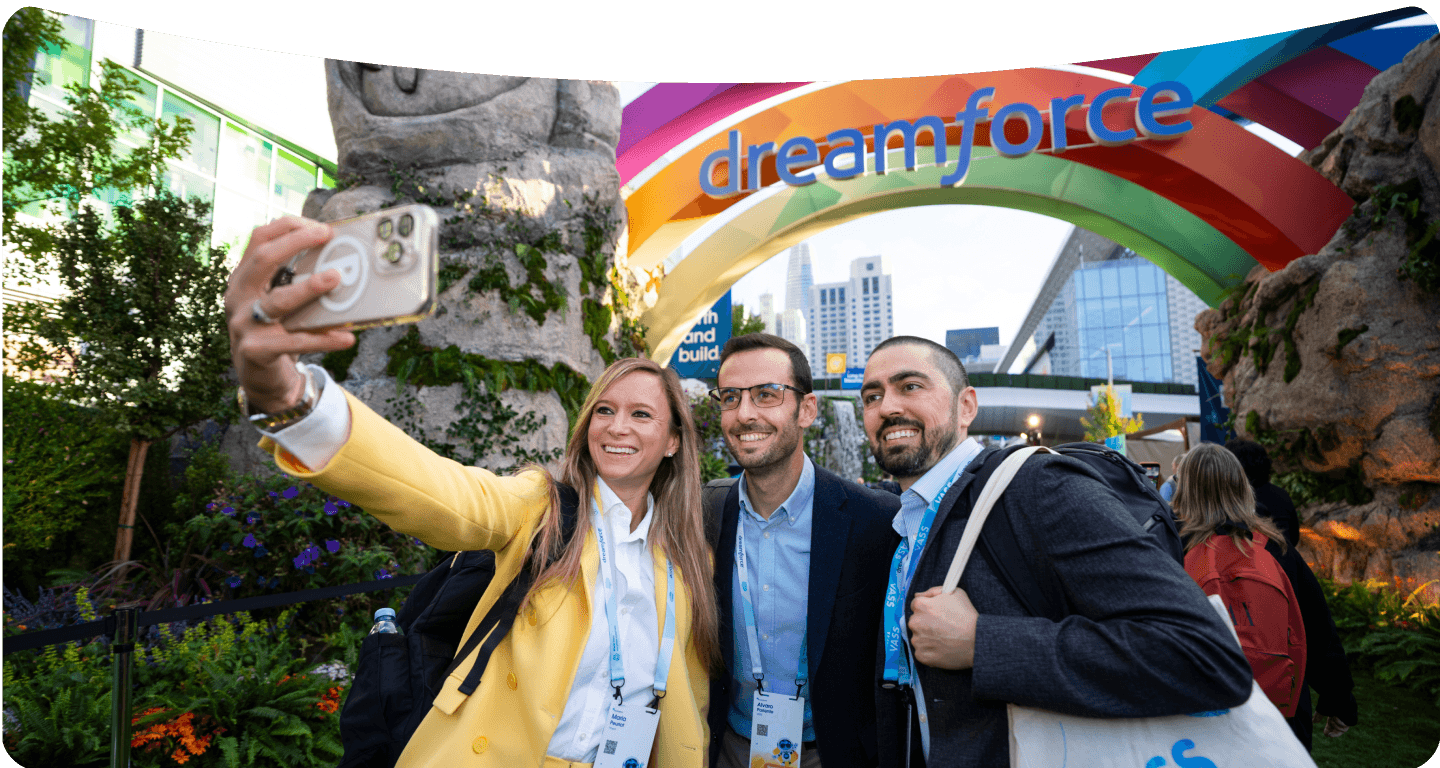 Three Dreamforce guests taking a selfie before a colorful Dreamforce entrance.