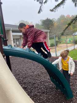 Two students play on equipment in the playground