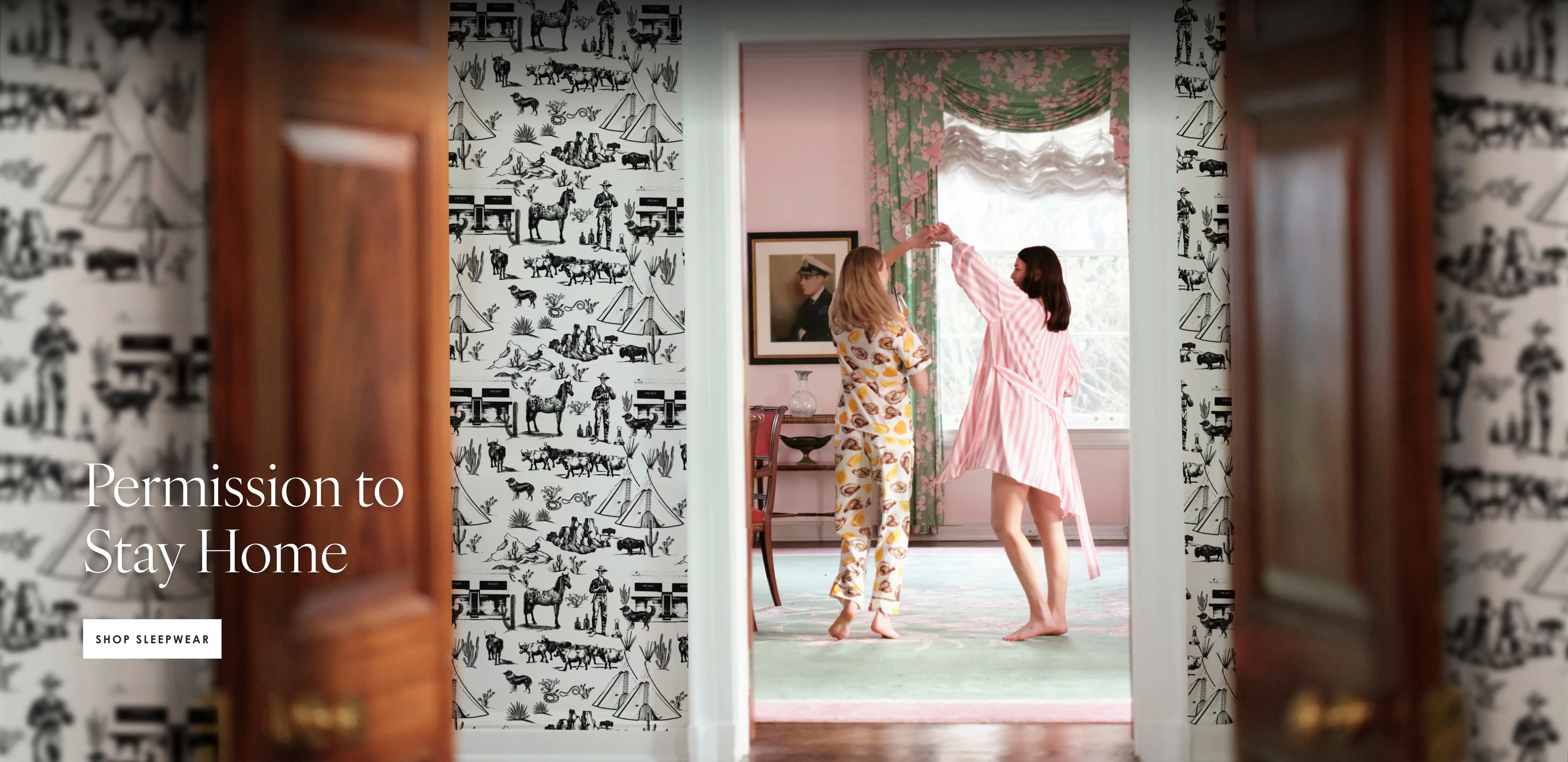 two women dancing in a room wearing katie kime pajamas. One woman is wearing the world is your oyster print pants set and the other is wearing the retro stripe pink robe
