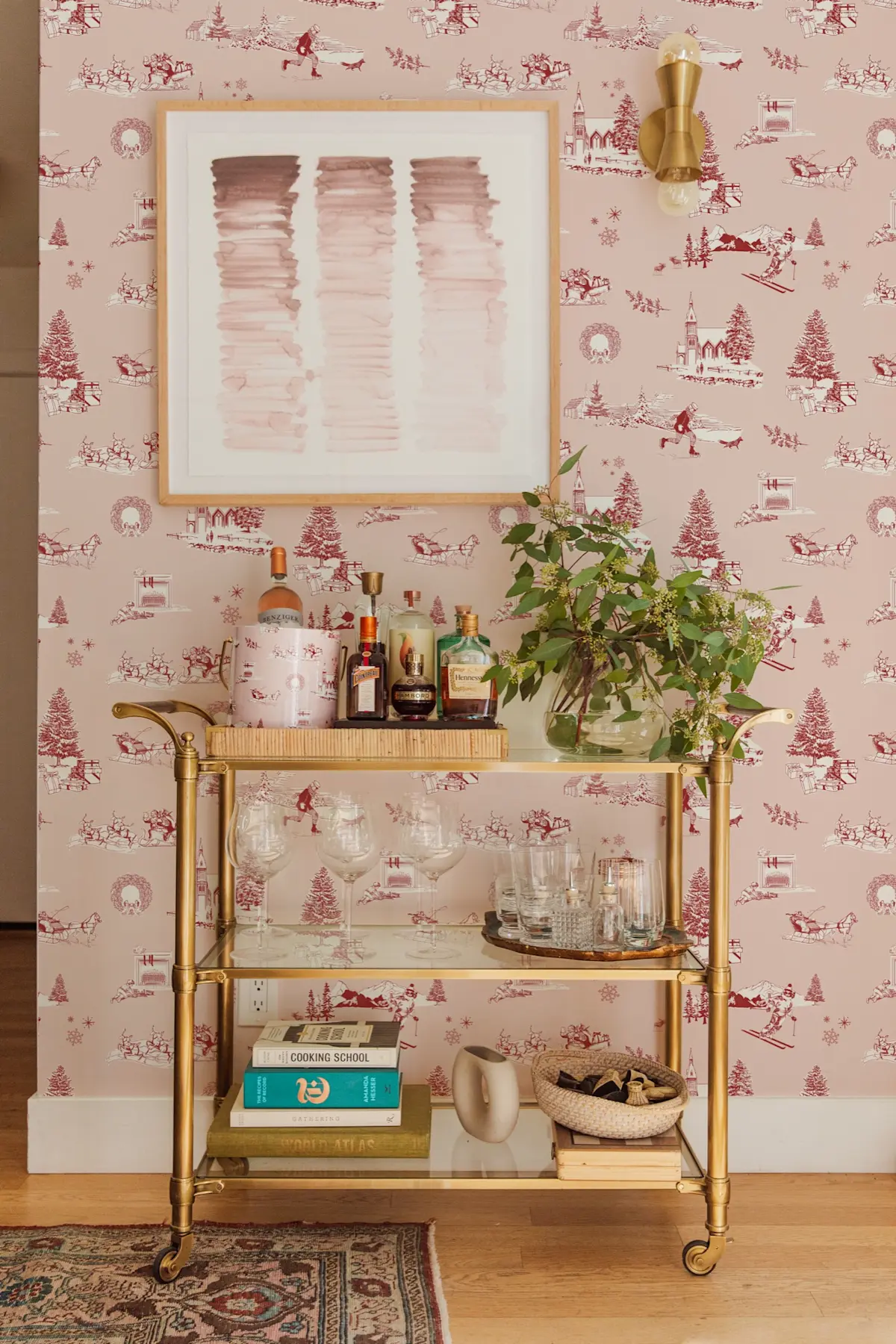 Brass bar cart in front of pink holiday toile wallpaper
