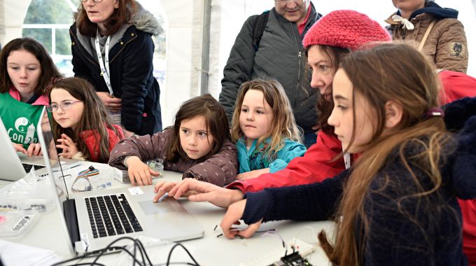 kids and volunteers around computer 