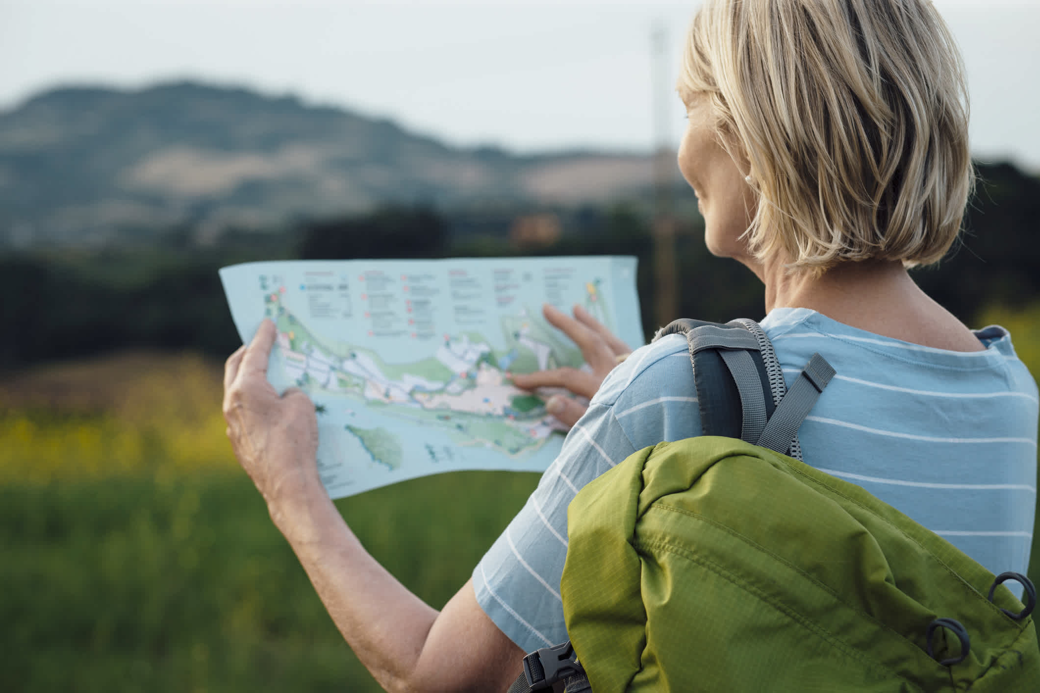 woman outdoors with map and backpack