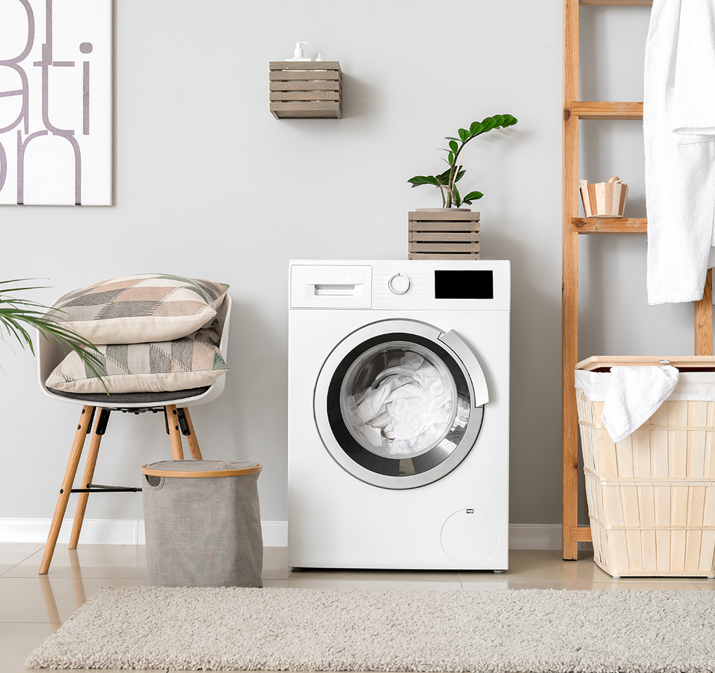 Waschküche mit Waschmaschine, Wäschekorb und Dekorationselementen