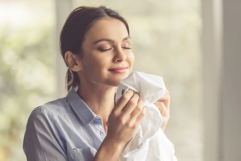 Woman Enjoying The Fresh Scent Of Clean Laundry