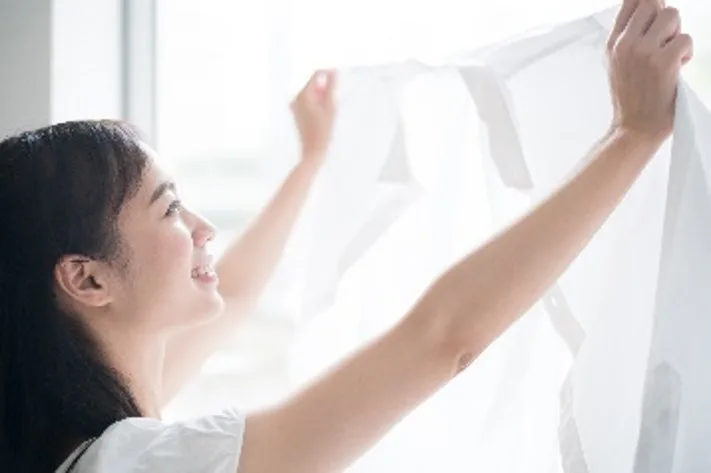 Woman Holding Freshly Washed White Shirt With A Smile
