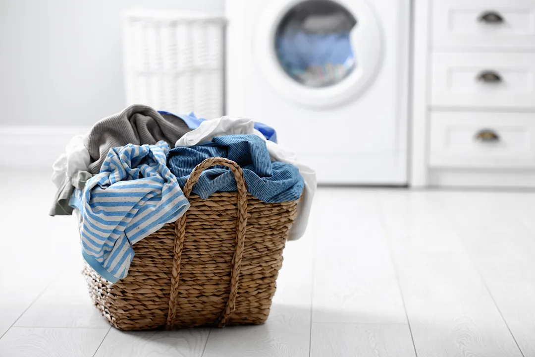 Wicker Basket Filled With Clothes In A Laundry Room