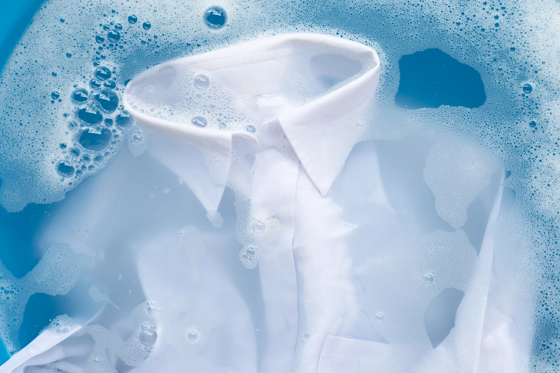 White Shirt Submerged In Bubbles And Blue Water