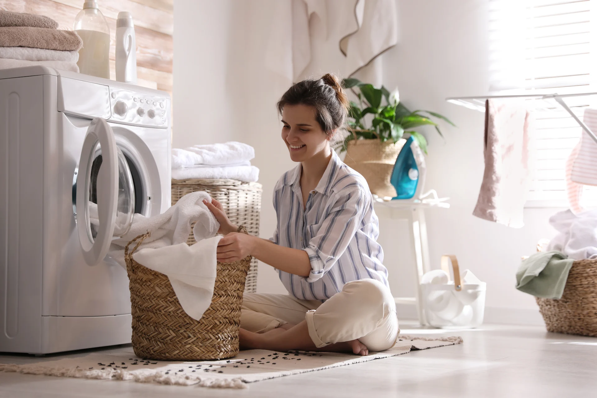Woman Placing Laundry In Washing Machine In A Bright Room