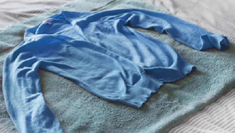 Blue Sweater And Towel Laid Out For Drying