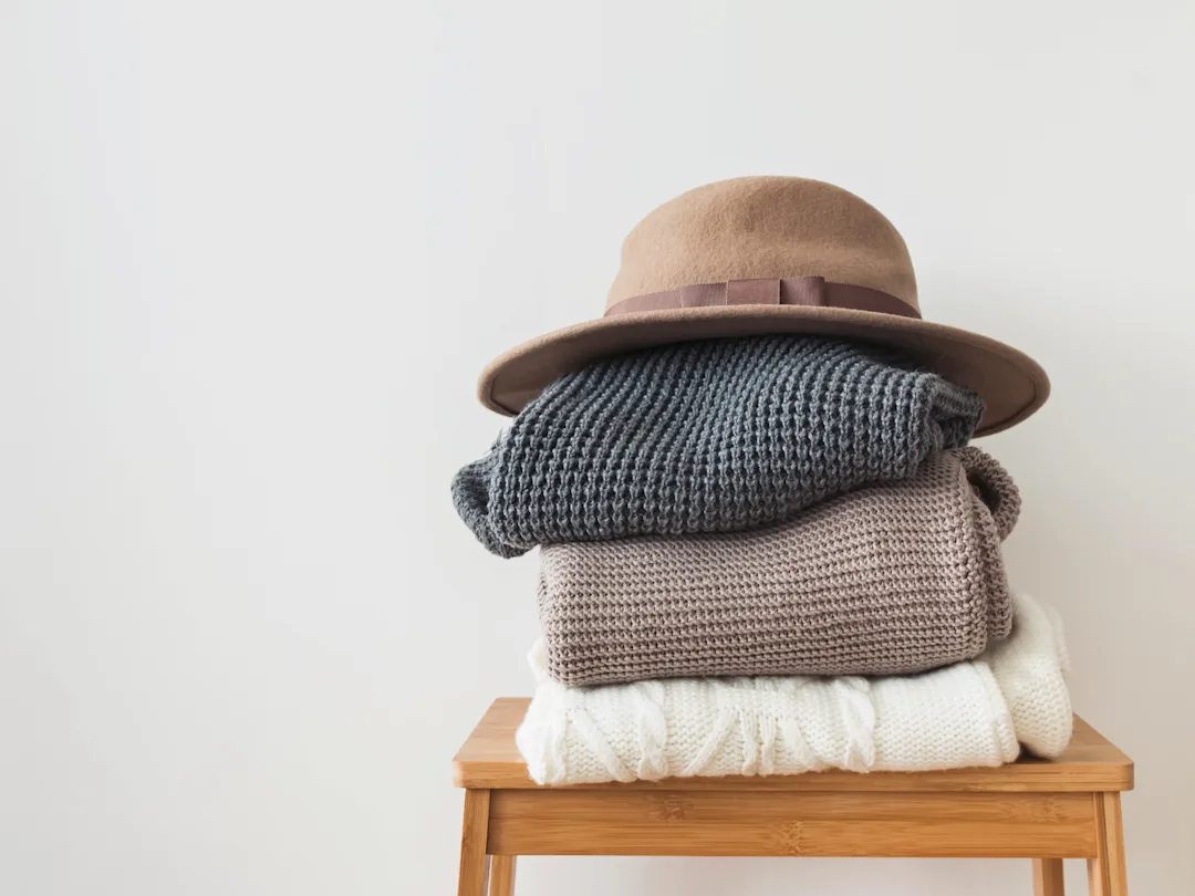 Stack Of Knitted Sweaters On A Wooden Stool