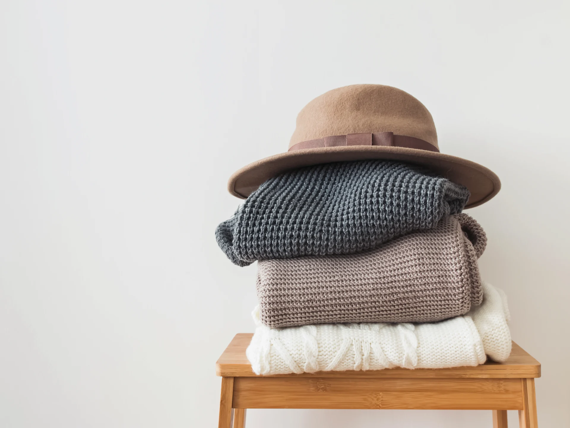 Stack Of Knitted Sweaters On A Wooden Stool
