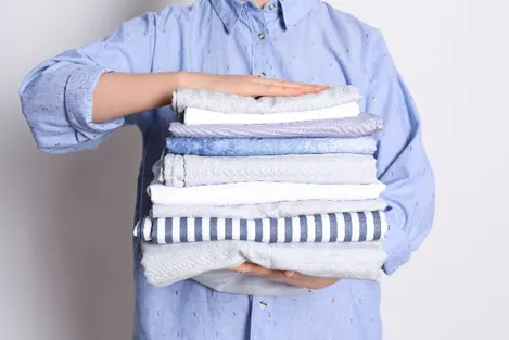 Person Holding Neatly Folded Stack Of Towels