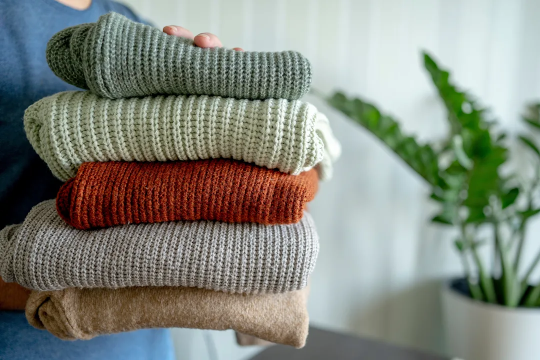 Stack Of Folded Knitted Sweaters In Various Colors