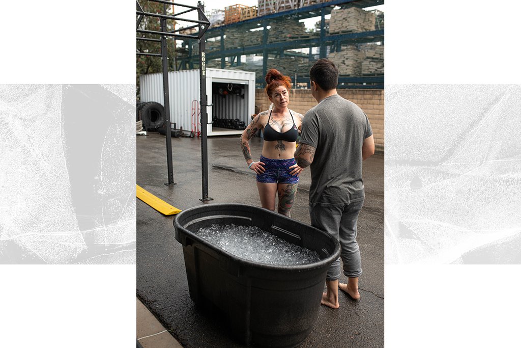 Two athletes standing outside of a cold plunge bath tub