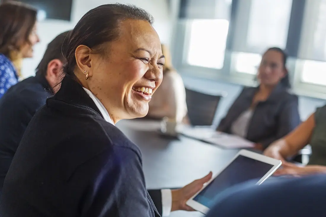 Asian businesswoman laughing in a meeting.
