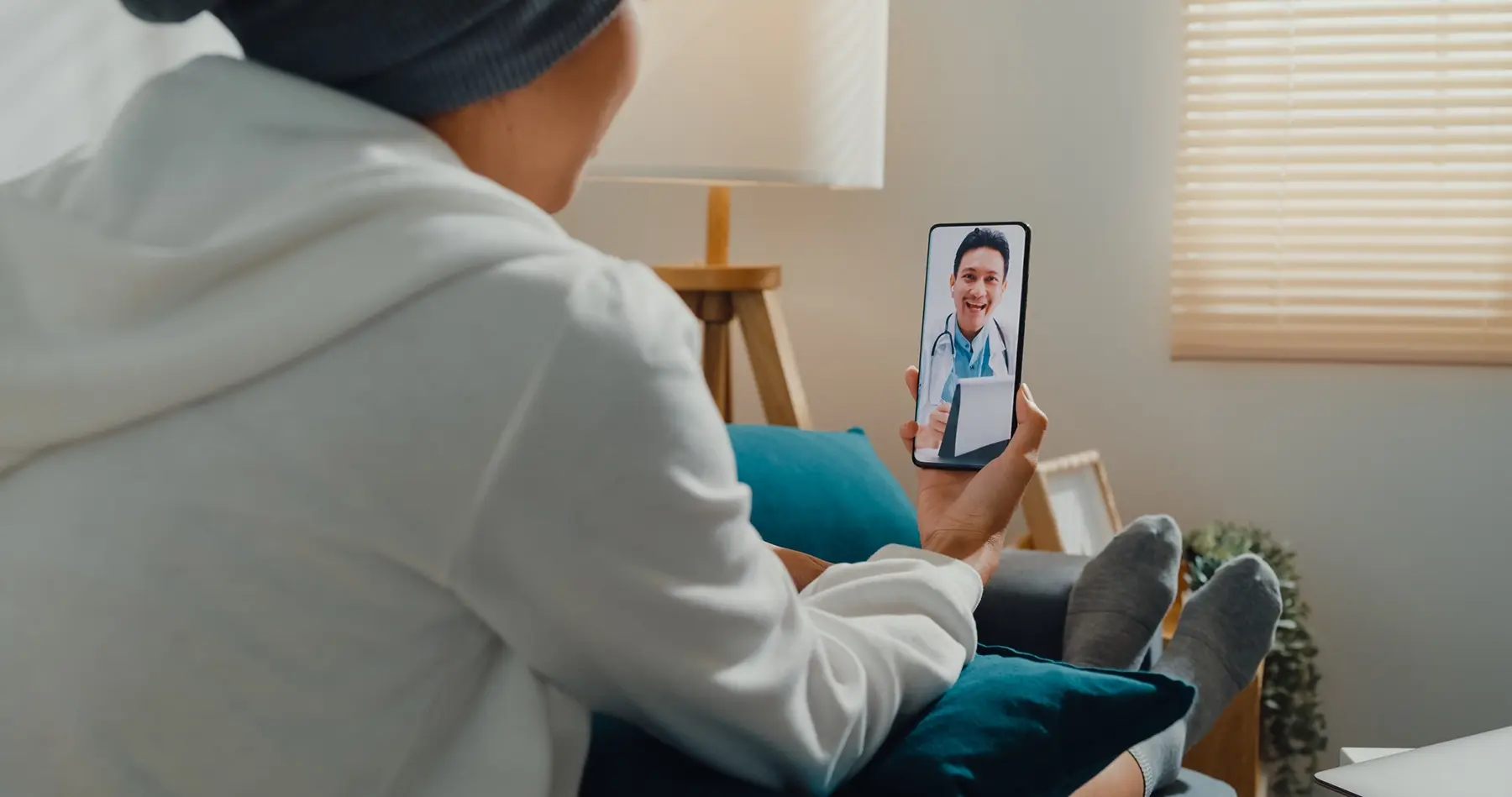 A woman using a smart phone to make a video call with a doctor.