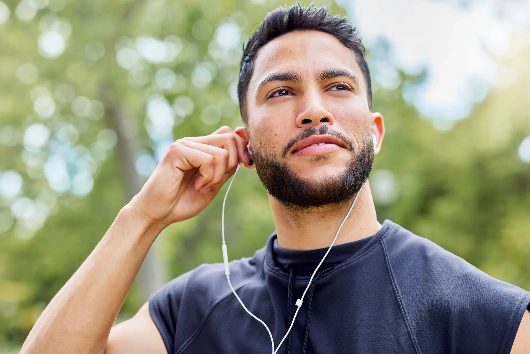 A man listening to music in a park.
