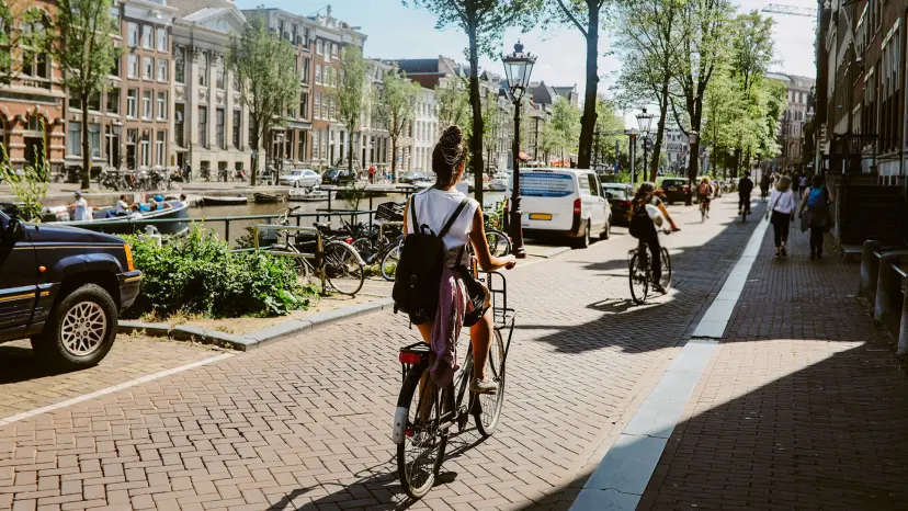 Woman cycling by a canal in the Netherlands.