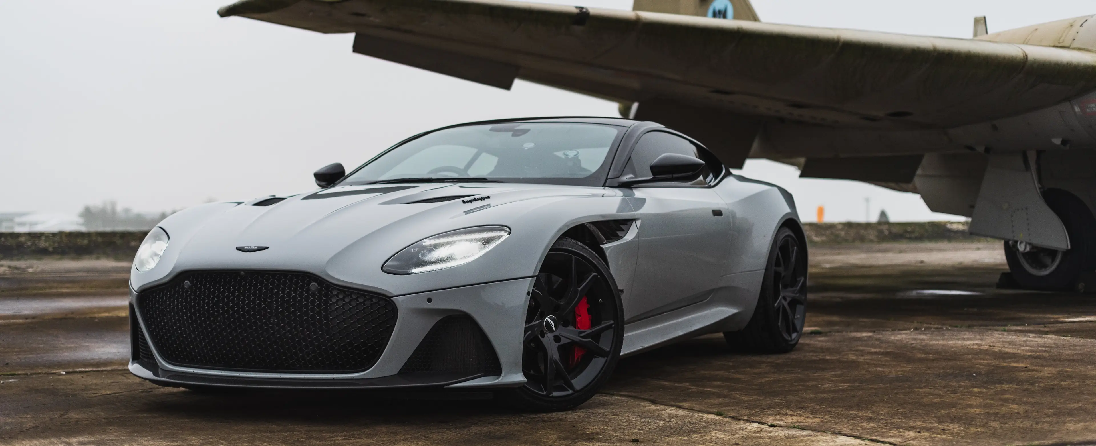 luxury car in front of plane