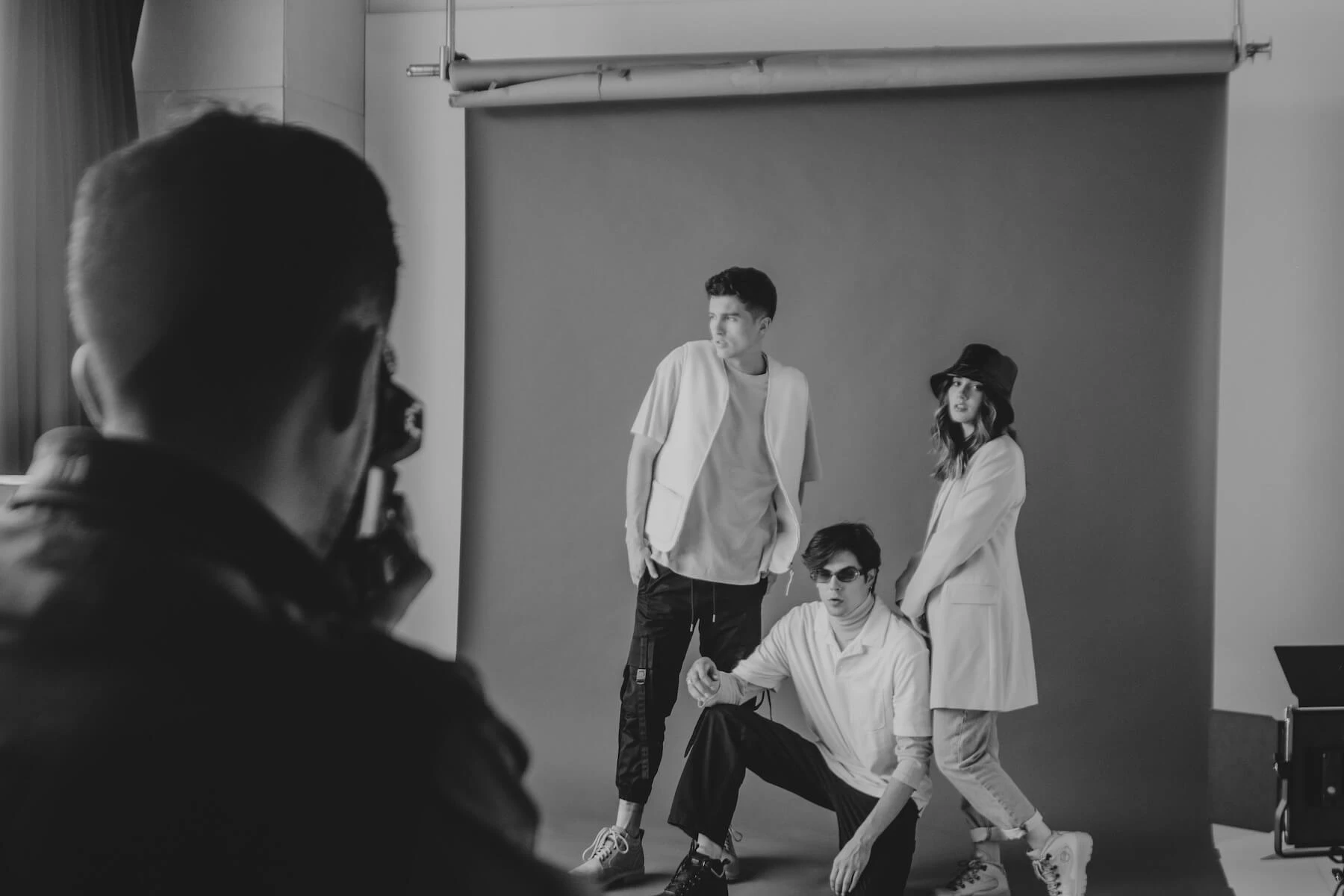 Black and white photo of young models posing energetically in a studio. Image credit to Amar Preciado