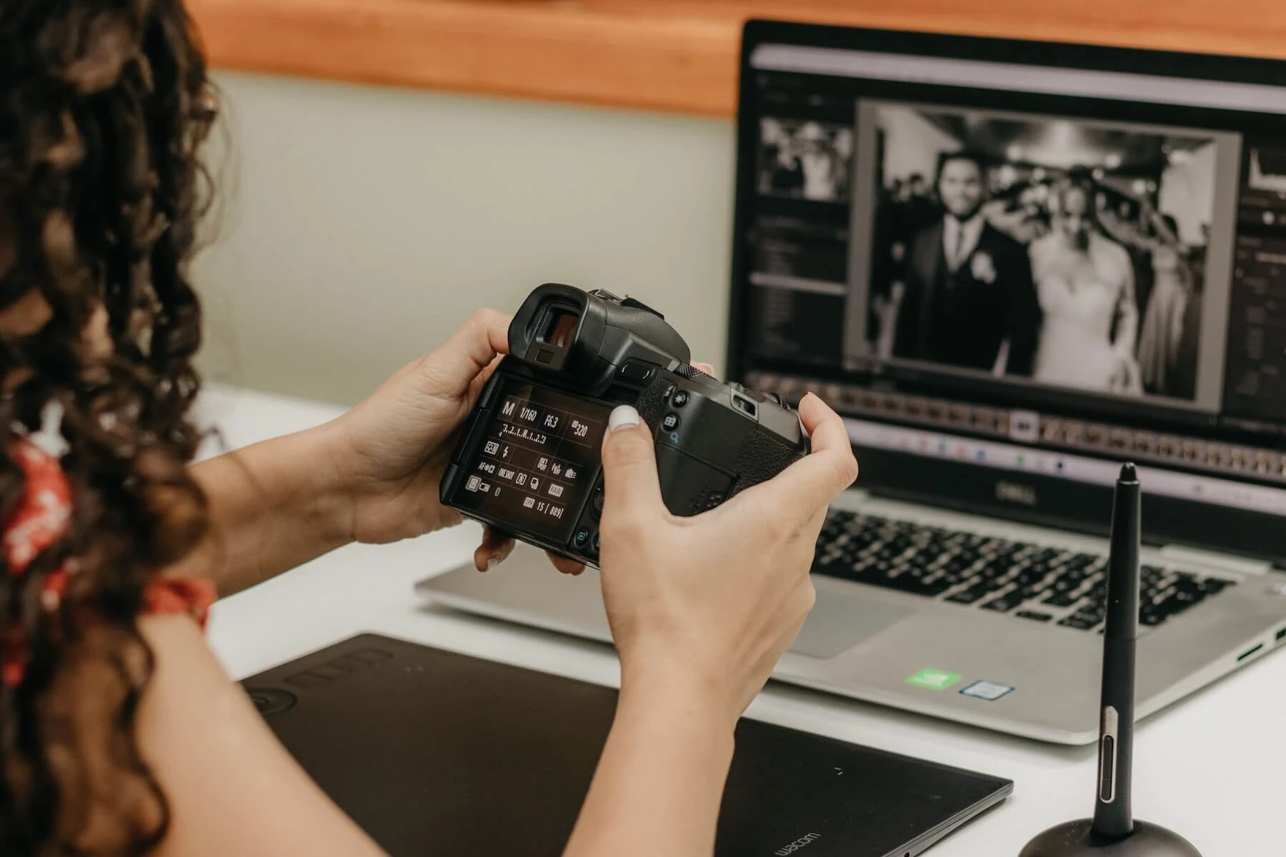 Photographer reviews camera settings while editing wedding photos on a laptop. Image credit to Kawê Rodrigues