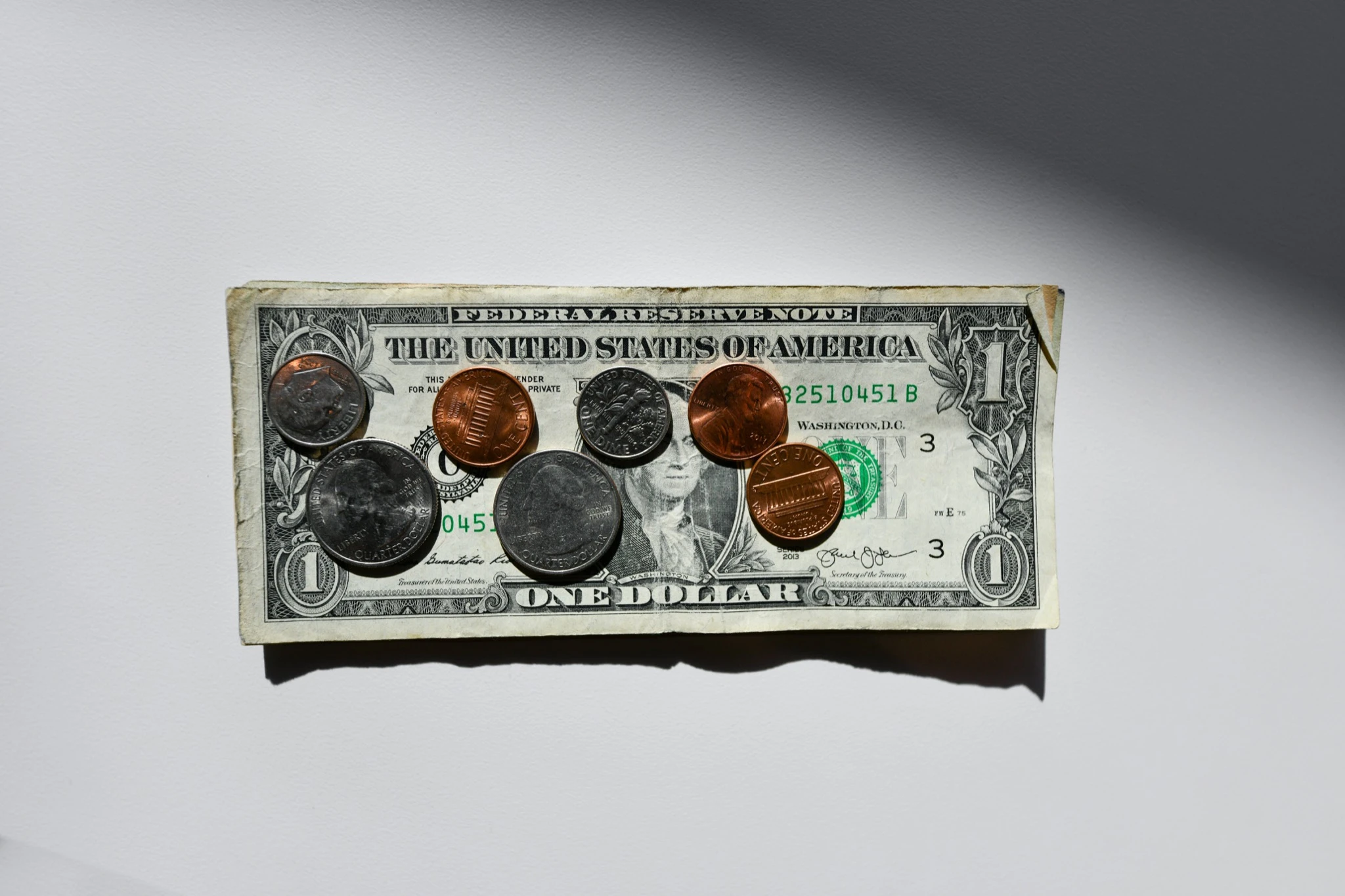 Image with coins on a $1 bill. 4 Proven Ways to Diversify Your Photography Income (in 2025).