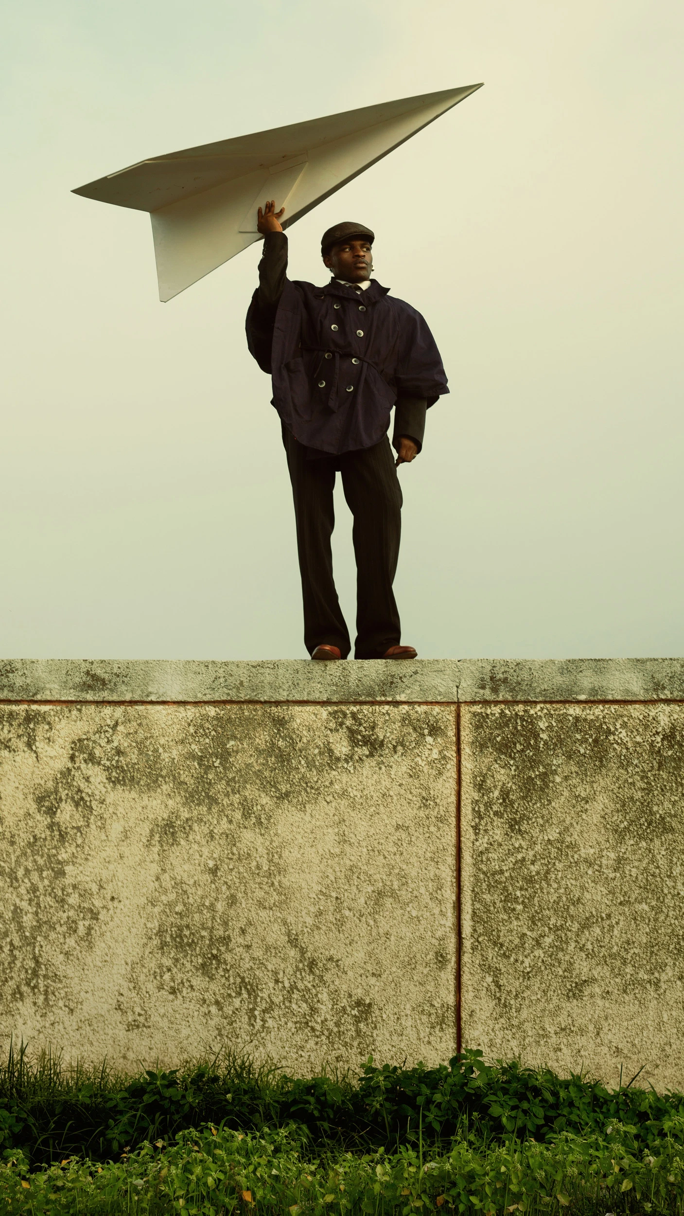Editorial portrait by photographer Etim E Essang featuring a model holding a large paper airplane, showcasing creative photography enhanced by Narrative’s AI photo culling and editing software for professional photographers.