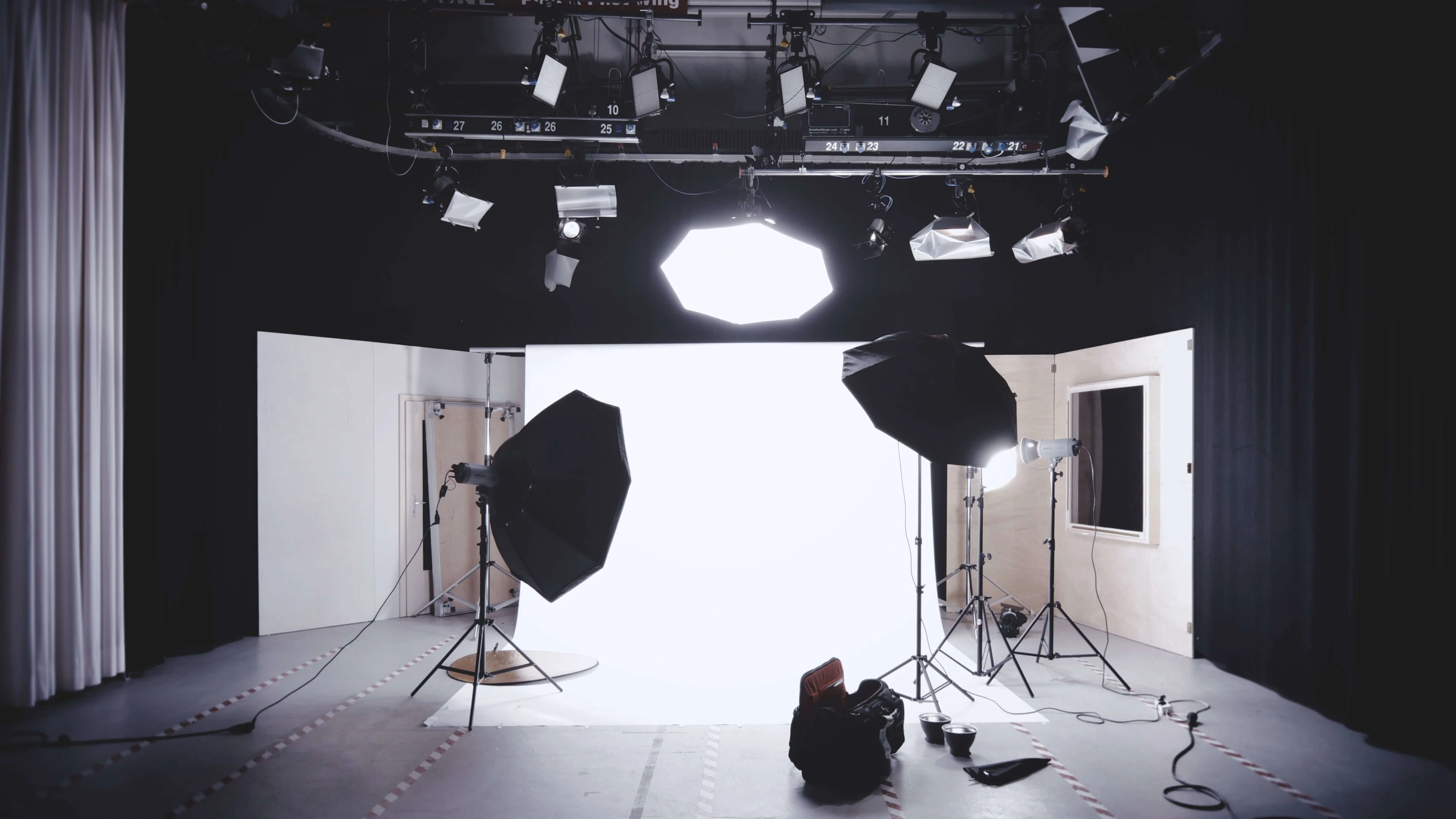 A well-equipped photography studio featuring lights, softboxes, and a white backdrop for professional shoots. Photo by Alexander Dummer