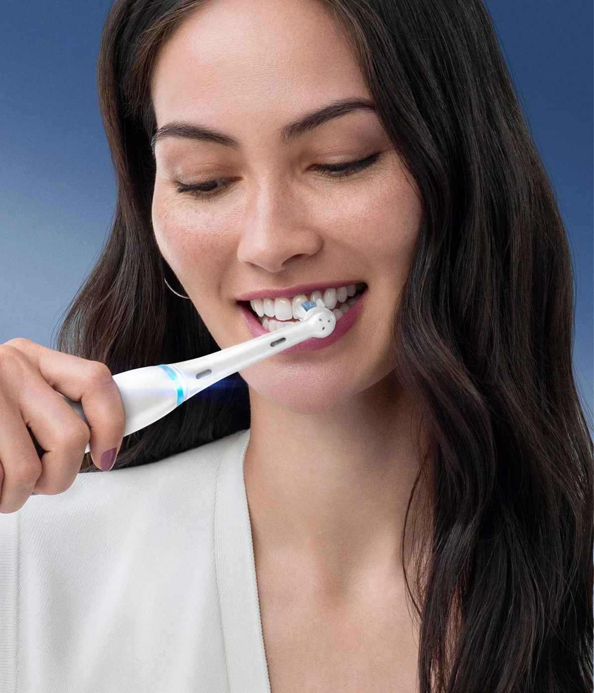 Woman brushing her teeth with Oral-B's iO Series 8 electric purple  toothbrush 