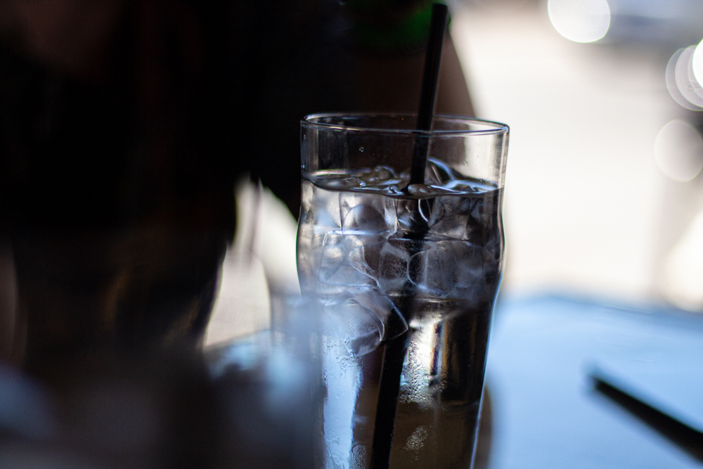 Iced water in a glass with a straw