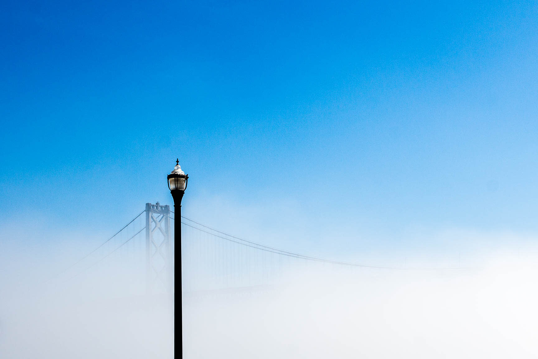 Lamp in front of a bridge fading into fog