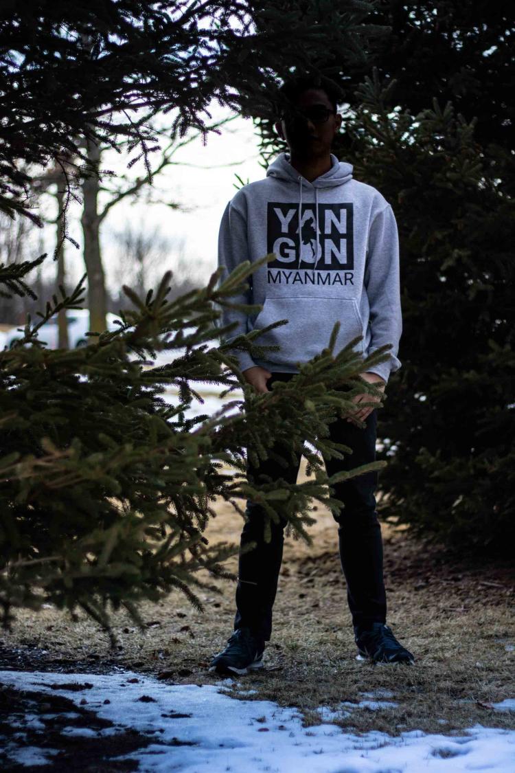 Person standing behind pine tree