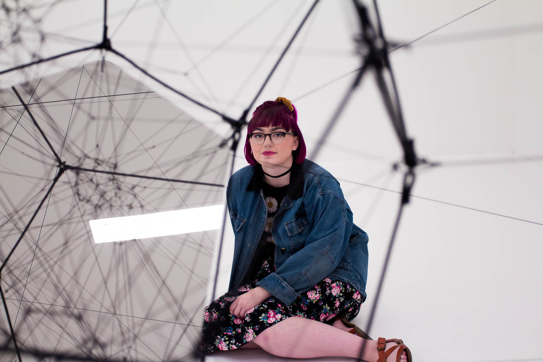 Person sitting on the floor next to artwork