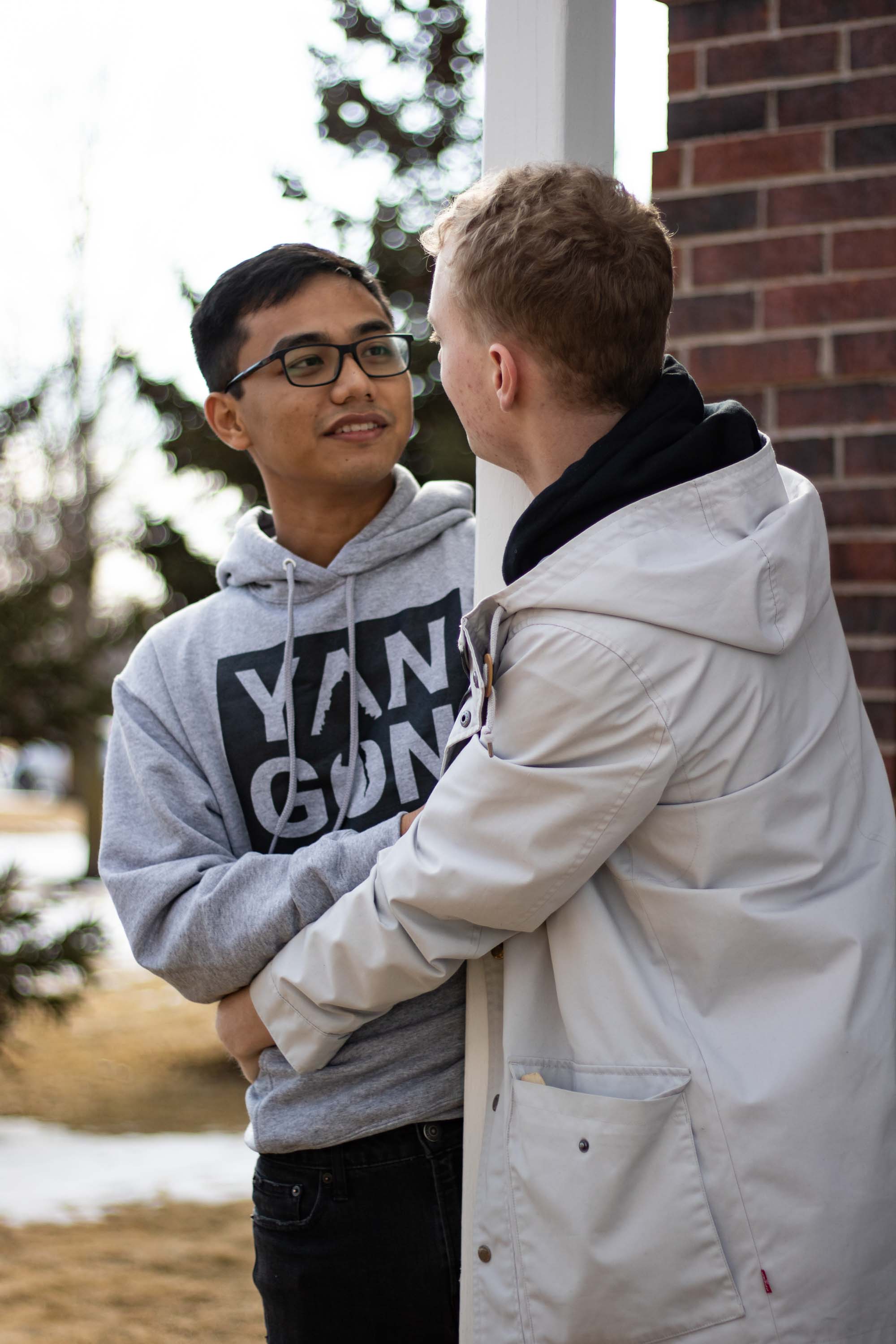 Two people looking each other in the eye while hugging pole