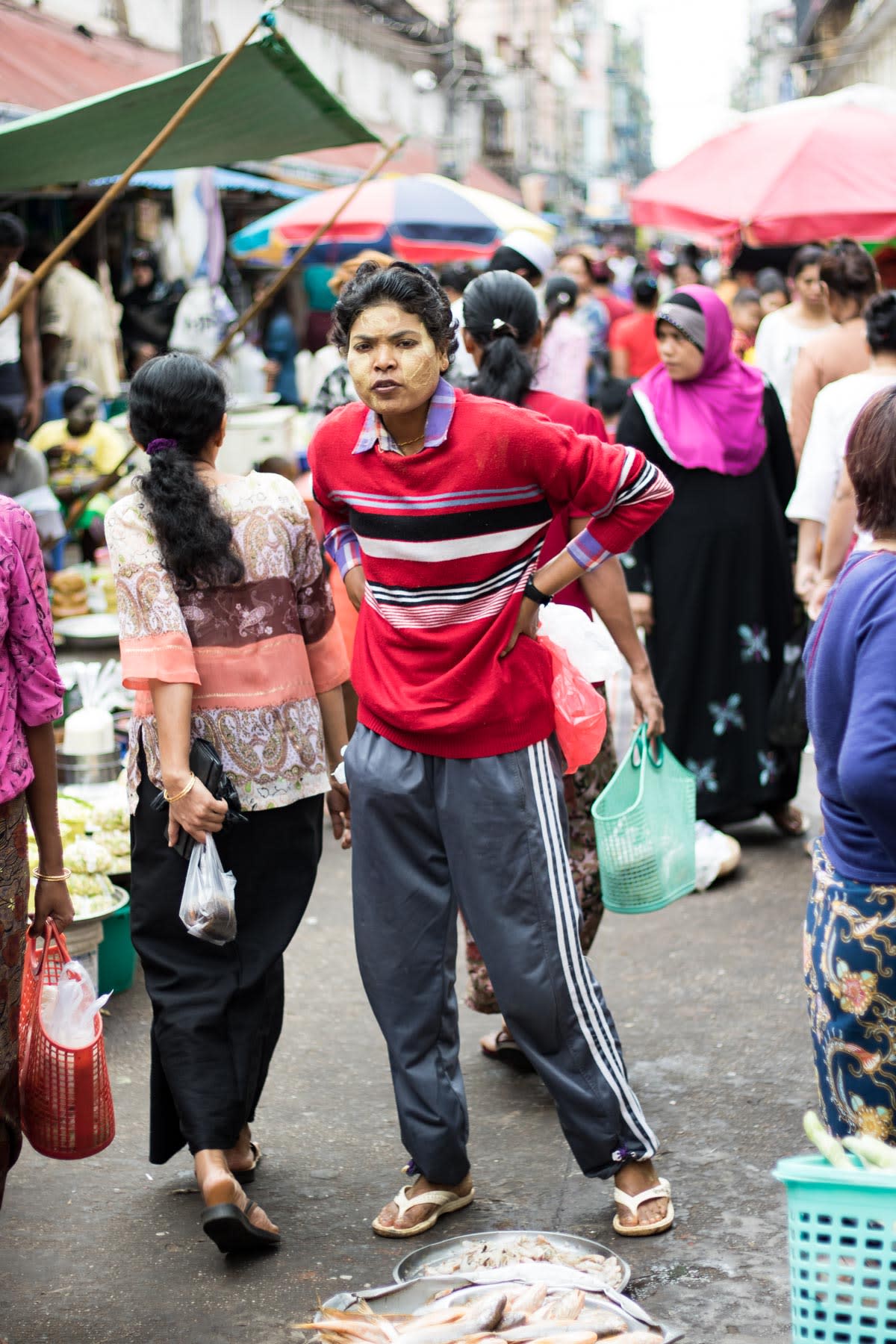 A person with their hands on their hips, squinting