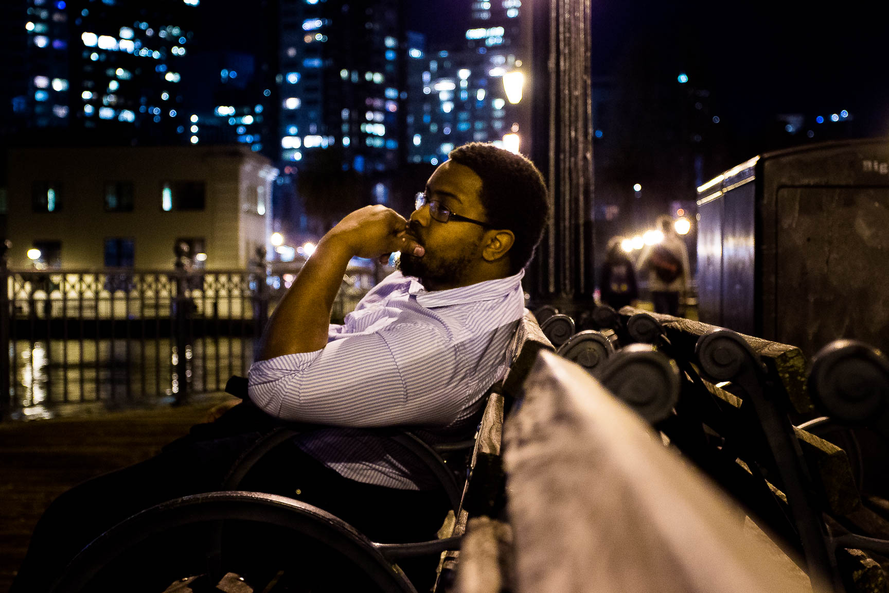 Person sitting on a bench, with hand on chin