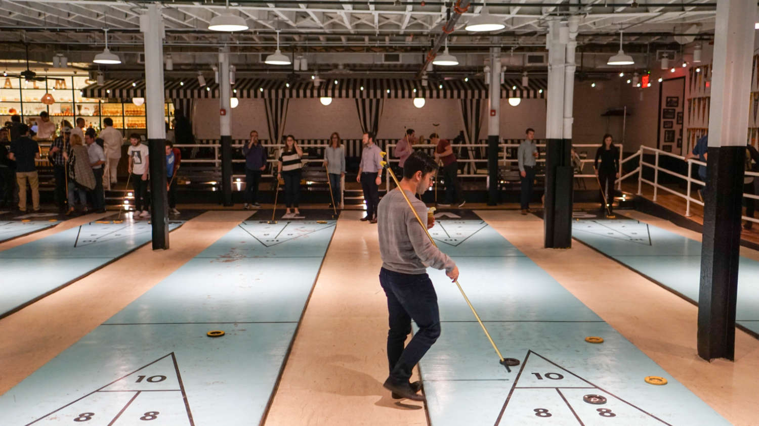 People playing shuffleboard at a Brooklyn Beta after party.